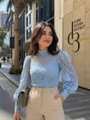 Blue lace blouse with beige trousers