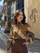 Patterned blouse with brown trousers