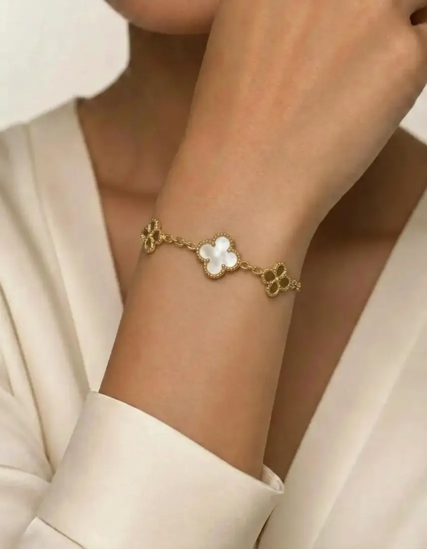 A close-up wrist shot shows a gold bracelet with white flower charms, added by the Bracelet Generator tool.