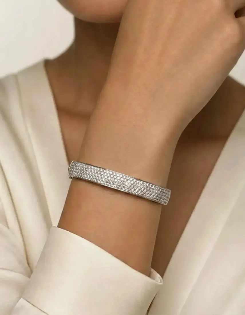 A close-up of a wrist in a white sleeve shows a pave diamond cuff generated by the Bracelet Generator tool.