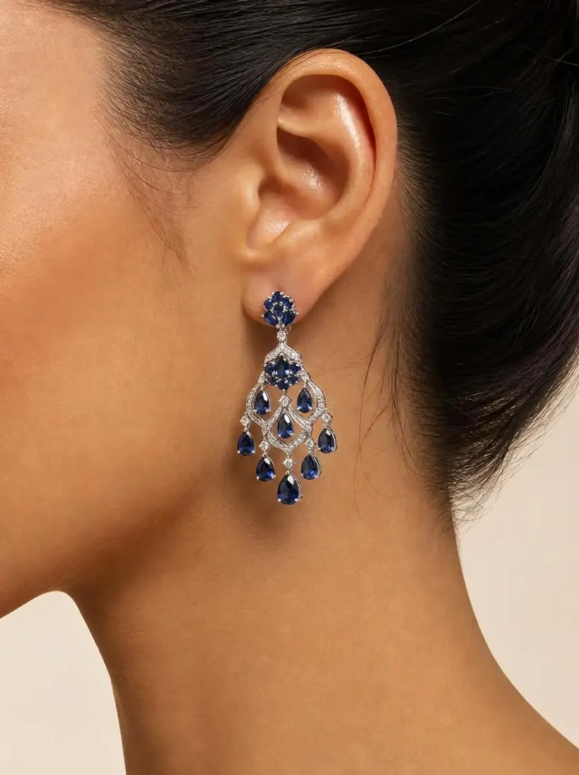 A close-up of an ear shows a sapphire and diamond chandelier drop earring generated by the Earring Generator tool.