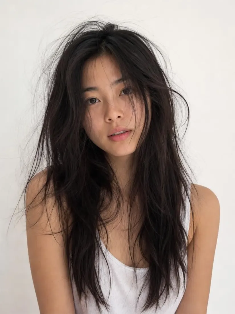 An Asian woman's long hair looks windblown and messy, before the Hair Fixer tool smooths it.