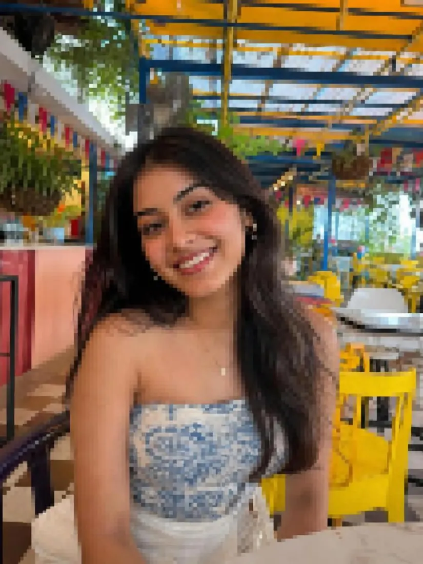A smiling woman at an outdoor cafe appears small and low-resolution, before the Image Enlarger sharpens it.