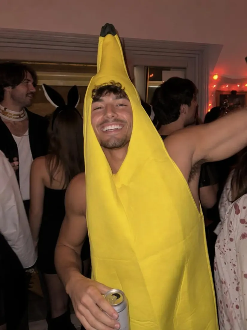 A man in a banana costume laughs at an indoor party, before the Mugshot Filter turns it into a fictional mugshot.
