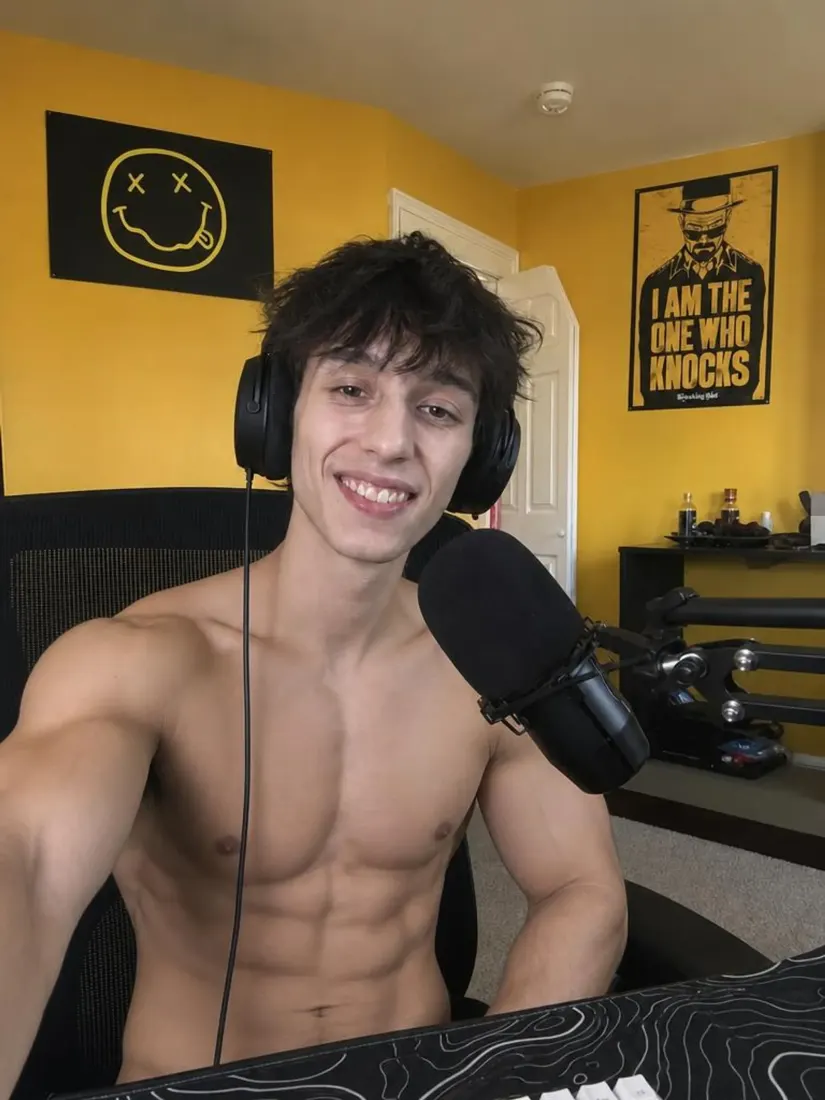 A shirtless muscular young man with headphones sits at a mic in a yellow bedroom, styled by the Muscle Filter tool.