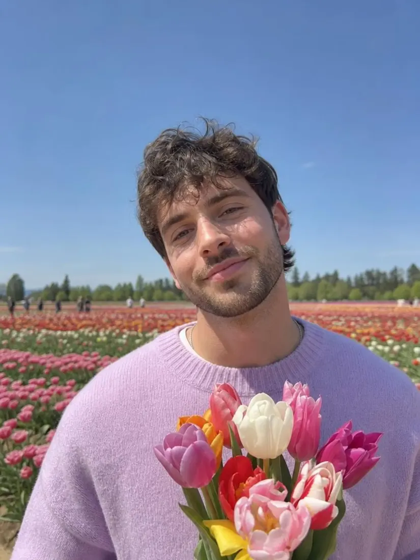 A man in a lavender sweater holds tulips in a tightly cropped photo, before the Photo Expander widens the scene.
