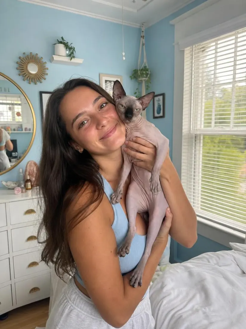 A woman holds a hairless cat in a blue bedroom, before the Photobooth Filter turns the photo into a booth strip.