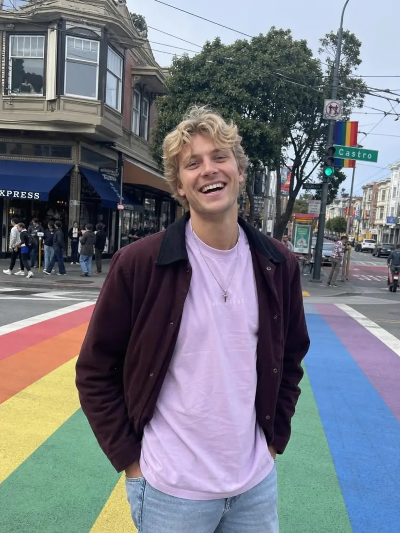 A blond man laughs on a rainbow-painted crosswalk, before the Video Game Filter turns him into a fighter character.